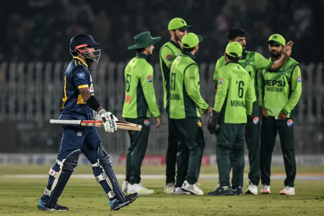 පකිස්ථානය සහ ශ්රී ලංකාව අතර පළමු එක්දින ක්රිකට් තරගයේදී කුසල් මෙන්ඩිස් දැවී යාමෙන් පසු ක්රීඩාගාරය වෙත පිය නගන අයුරු. පසුපසින් පකිස්ථාන ක්රීඩකයින් හය දෙනෙක් සිටිති.