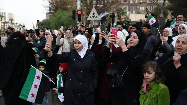 سوريون يشاهدون عرضاً عسكرياً في العاصمة دمشق (8 كانون الأول/ديسمبر 2025)