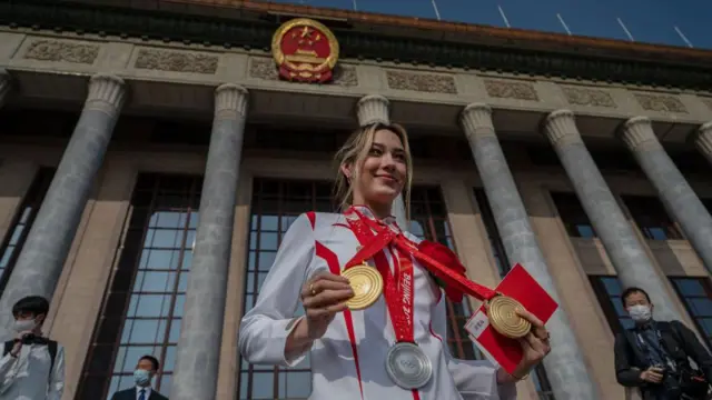 谷爱凌挂上北京冬奥会的奖牌站在人民大会堂前