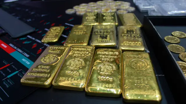 图片显示有多条1000g的黄金金条及一些金币。