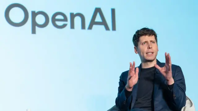 سام ألتمان متحدثاً في جلسة حوارية وقد كُتب وراءه اسم شركة أوبن إيه آي Open AI
