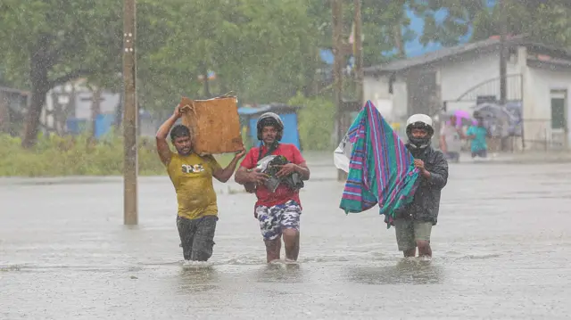 ජලගැල්මකට හසුවූ තිදෙනෙක් වැස්සට තෙමෙමින් ඇවිද යන ආකාරය