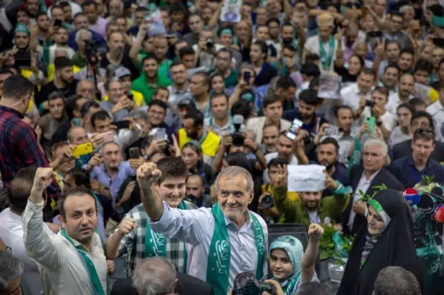 ፕሬዚዳንት በደጋፊዎቻቸው መካከል ቆመው