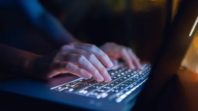 የላፕቶፕ ቁልፎችን እየተጫነ ያለ እጅ