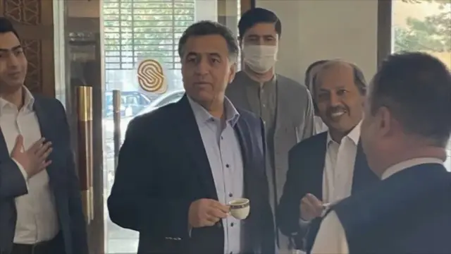 عکس فیض حمید رئیس سابق آیاسیای در سفرش به کابل در حالی که یک پیاله چای بدست دارد.