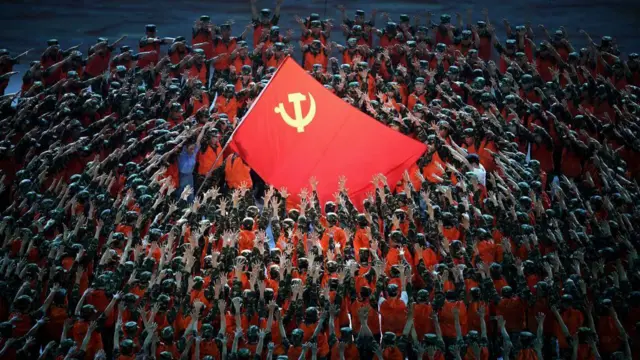 一群舞蹈者围着一面中共党旗