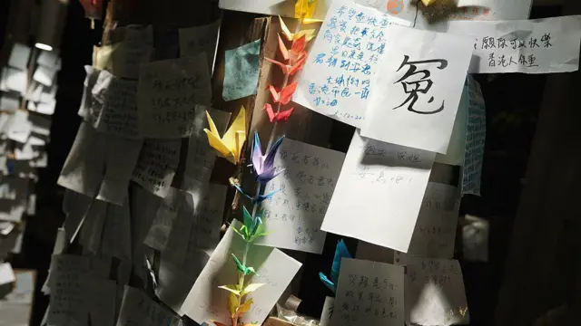 哀悼者摆放的摺纸,伴着一张纸写上“冤”纸条。