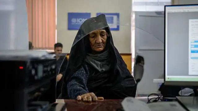 تصویر یک زن مهاجر در یکی از مراکز توزیع کمکهای نقدی در مرکز ایران و افغانستان