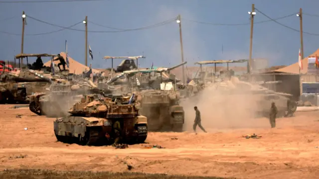 የእስራኤል ጦር ታንኮች በአቧራማ መንገድ ላይ