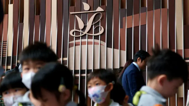 一群学童在香港立法会大楼内参观,背景为大型立法会标志(23/10/2025)