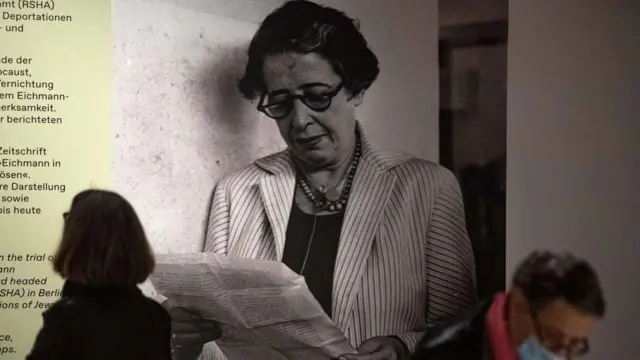 أحد الزوّار إلى جانب صورة للفيلسوفة والمنظّرة السياسية الألمانية-الأمريكية حنّة آرنت خلال العرض التمهيدي للصحافة لمعرض "حنّة آرنت والقرن العشرون" في المتحف التاريخي الألماني (DHM) في برلين في 6 مايو/أيار 2020