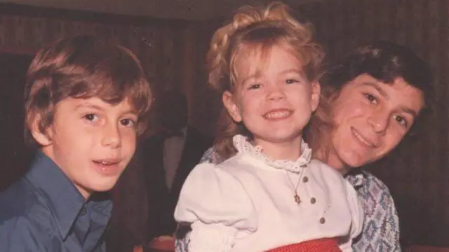 一张彩色照片中,瓦尔与她的两位兄弟在童年时合影,她坐在其中一位兄弟的腿上,三人都对着镜头微笑。