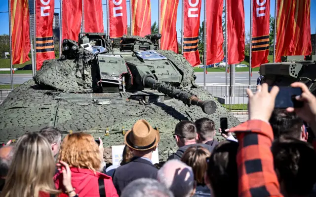 بازدیدکنندگان در ۱ مه ۲۰۲۴ در مجموعه یادبود جنگ جهانی دوم در تپه پوکلونایا در مسکو، نفربر زرهی سوئدی «سیوی ۹۰۴۰» را که نیروهای روس در اوکراین به غنیمت گرفتهاند تماشا میکنند. وزارت دفاع روسیه نمایشگاهی از «سلاحها و تجهیزات نظامی غربی» بهغنیمتگرفتهشده در اوکراین برپا کرده است. این خودرو سبزرنگ و با توری استتاری پوشانده شده و برجک توپ آن به سمت جمعیت است.