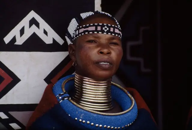 አንገቷ ላይ ከጨሌ የተሰራ ትልቅ ጌጥ ያደረገች ሴት