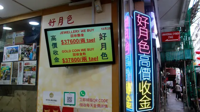 好月色黄金有限公司的店面,电脑屏幕上展示回收饰金及回收金粒的价格。