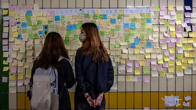 2025年12月1日,在香港大埔宏福苑附近的一条行人隧道墙上,可以看到人们为11月26日致命火灾的遇难者留下的手写悼念卡片。