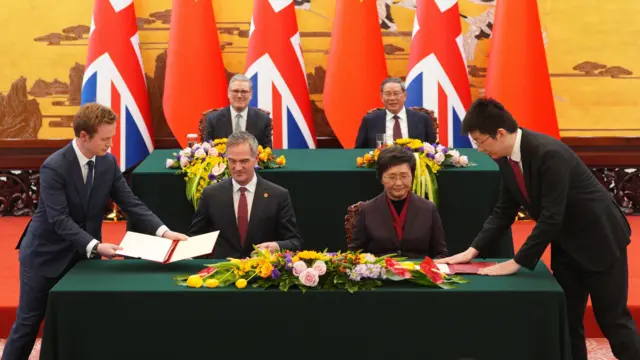 北京人民大会堂内,英国首相基尔·斯塔默爵士(后左)与中国总理李强(后右)见证英国商业及贸易大臣彼得·凯尔(Peter Kyle;前左)与中国人力资源和社会保障部部长王晓萍(前右)签署双边合作协议(29/1/2026)