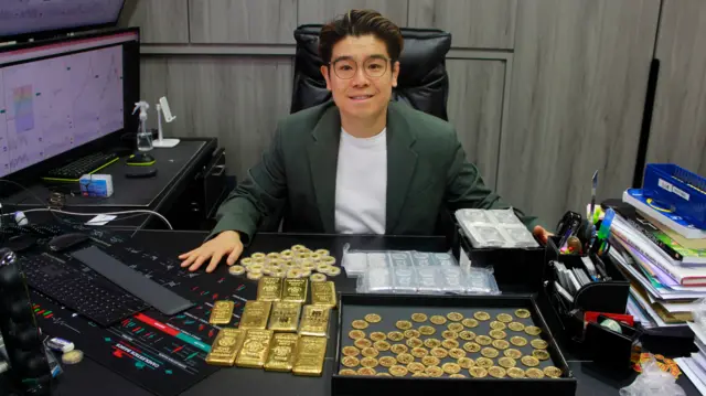 帝锋金融集团行政总裁、香港黄金交易所董事李俊亨的办公桌前,放满了黄金产品,包括金条、金币及银条。