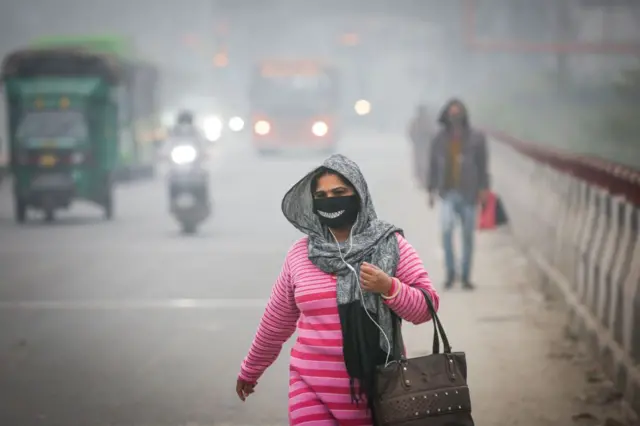 یوه مېرمنه په ککړه هوا کې روانه ده