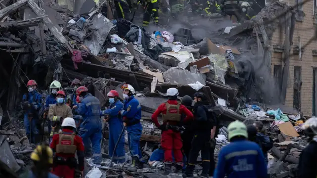 救援人員在基輔一棟被俄羅斯飛彈襲擊摧毀的公寓樓瓦礫中搜尋失蹤者