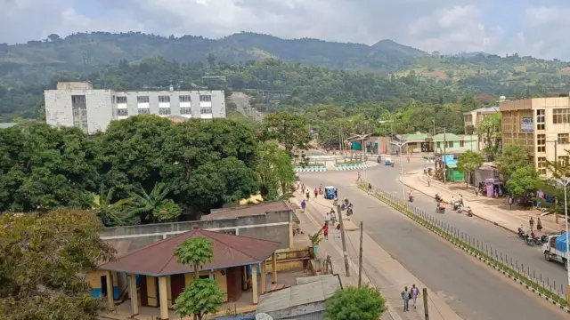 ከከፍታ ላይ የተነሳው በዚህ የጂንካ ከተማ ዋና አደባባይ ፎቶ ላይ የነዋሪዎች እና ተሽከራካሪዎች እንቅስቃሴ ይታያል።በግራ እና በቀኝ ህንጻዎች የሚታዩ ሲሆን ከፊት ለፊት በደን የተሸፈነ ተራራማ አካበቢ በስፋት ተዘርግቷል