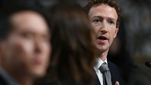 马克·扎克伯格(Mark Zuckerberg)身穿西装、打灰色领带,在美国参议院司法委员会发言