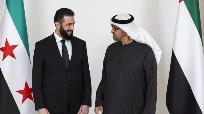 احمد شرع در کنار محمد بن زاید رئیس امارت و پرچمهای دو کشور