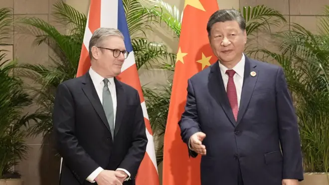 身穿西服的基尔·斯塔默爵士(左)与习近平(右)在巴西里约热内卢G20峰会周边会晤,两人站在英国与中国国旗前合照(18/11/2024)