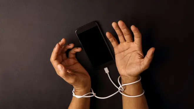 በቻርጀር ገመድ የታሰሩ እጆች