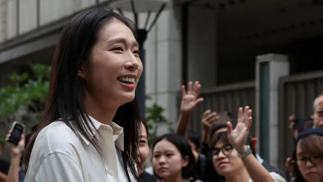 身穿白色衬衫的江旻憓在香港北角出席参选发布会时向媒体记者展露笑容(3/11/2025)