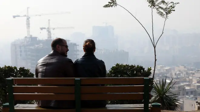دو نفر بر روی نیکت به آسمان آلوده تهران مینگرند
