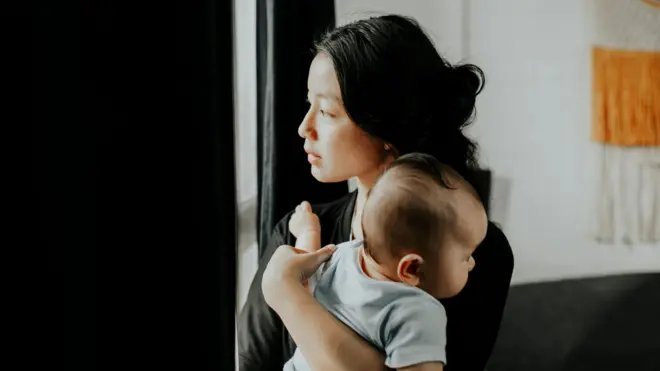 一名女性抱着婴儿。