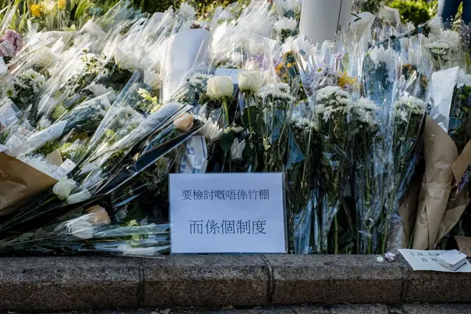 近日来,不少市民到宏福苑休憩处献上悼念花束,当中有人在纸皮上写道“要检讨的不是竹棚,而是制度”。