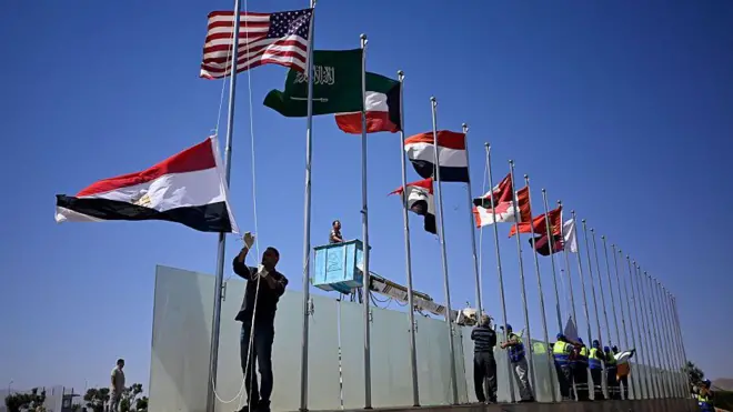 کارگران پرچم کشورهایی را که رهبرانشان از شرم الشیخ بازدید میکنند، بالا میبرند