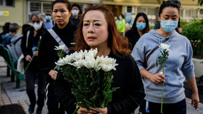 People lay floral tributes for the victims of the fire at the Wang Fuk Court residential estate in the Tai Po district of Hong Kong, China, 29 November 2025. The city is mourning 128 people killed in the high-rise apartment fire, with about 200 others still unaccounted for.