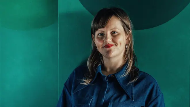 萨宾·泽特勒 (Sabine Zetteler) 穿着蓝色衬衫,背景为绿色