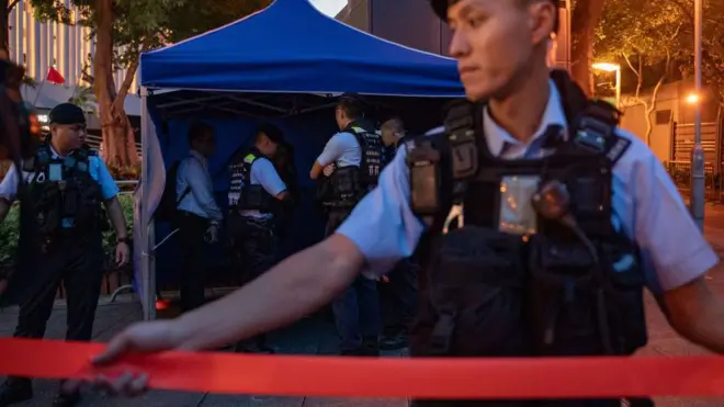 JUNE 03: Police officers detain a woman as she held a cell phone light at Victoria Park where people traditionally gathered annually to mourn the victims of China's Tiananmen Square crackdown in 1989 on June 04