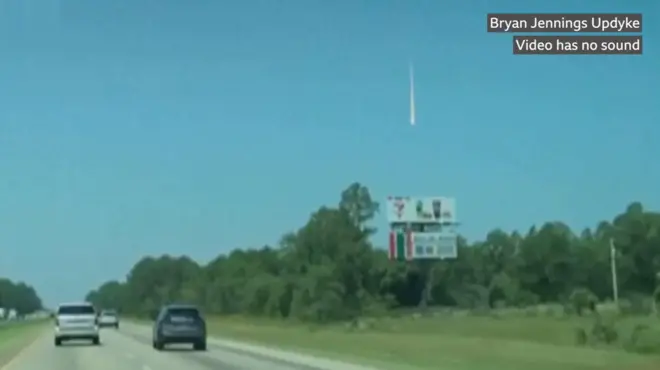 كرة نارية ضخمة تُرى في سماء جنوب شرق الولايات المتحدة نهاراً. تظهر في الصورة أشجار خضراء وسيارات.