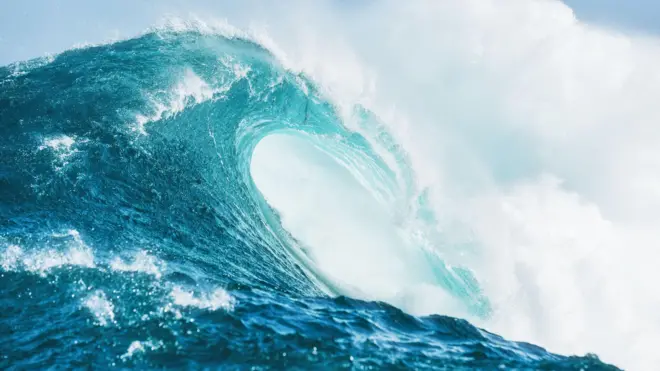 نمای نزدیک از جزئیات موج قدرتمند آبی فیروزهای که در اقیانوس آزاد در یک بعد از ظهر آفتابی میشکند