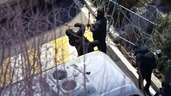 2025 年 1 月 15 日,韩国首尔,警方剪断尹锡悦官邸入口处的铁丝网。