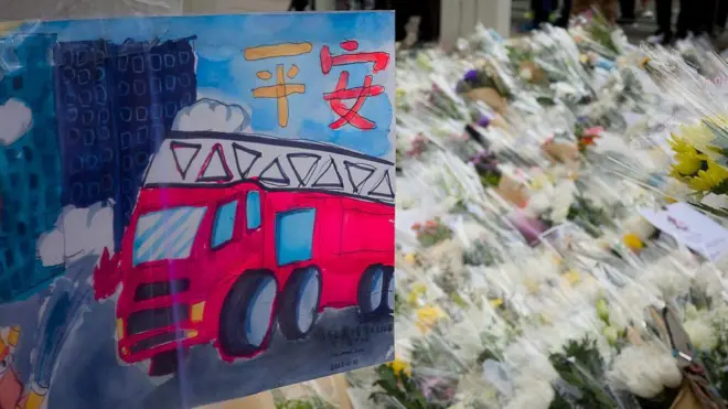 2025年11月30日,人们在香港大埔区宏福苑火灾现场附近摆放鲜花和画作,悼念这场致命火灾的罹难者。