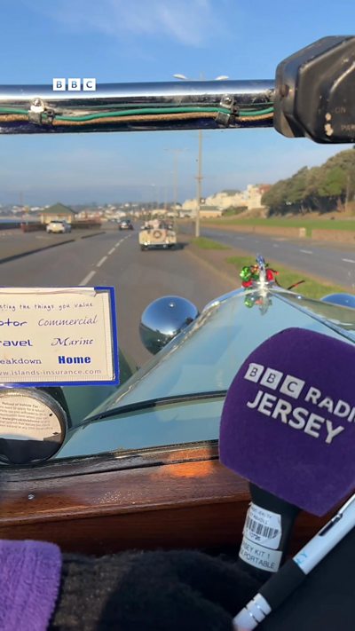 A group of classic cars drive along the foreshore in Jersey