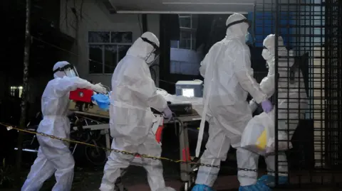 A picture of 3 people wearing white suits. They have masks on.