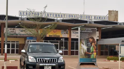 A picture taken on February 24, 2016 shows the entrance of Diori Hamani International airport of Niamey, with a black car in the foregrouns