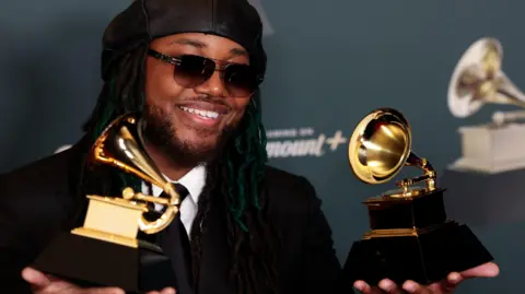 EPA/Shutterstock Leon Thomas holding two Grammy Awards