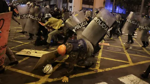 Demonstrators clash with riot police officers during a protest in Lima, Peru