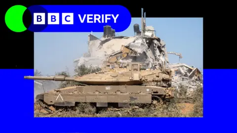 An Israeli tank parked next to the ruins of a building in the Gaza Strip. 