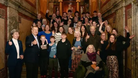 Residents from Dull at the Hotel Imperial in Vienna smiling and waving at the camera.