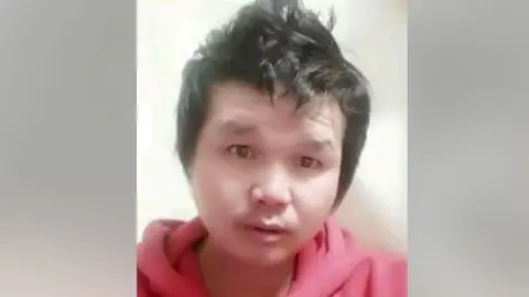 Photograph of Suthisak Rintalak. His hair is styled pointing up and he is wearing a red hoodie