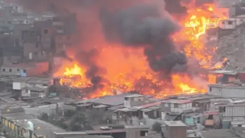 Drone footage shows a huge plume of smoke rising from a fire